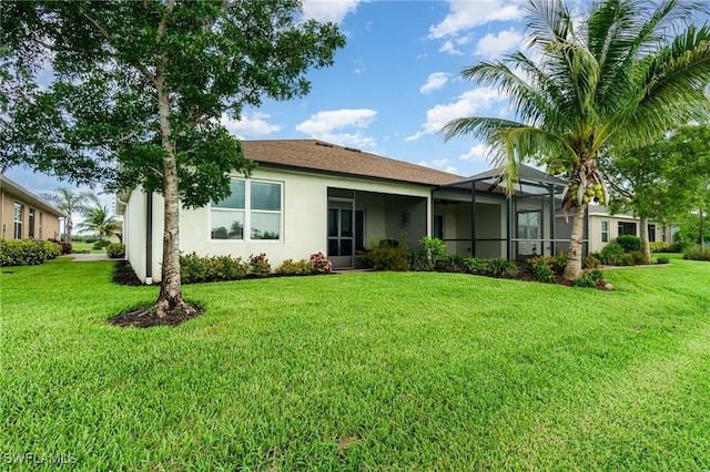 20095 Fiddlewood Ave, North Fort Myers, FL 33917 - back of property with stucco siding, a yard, and glass enclosure