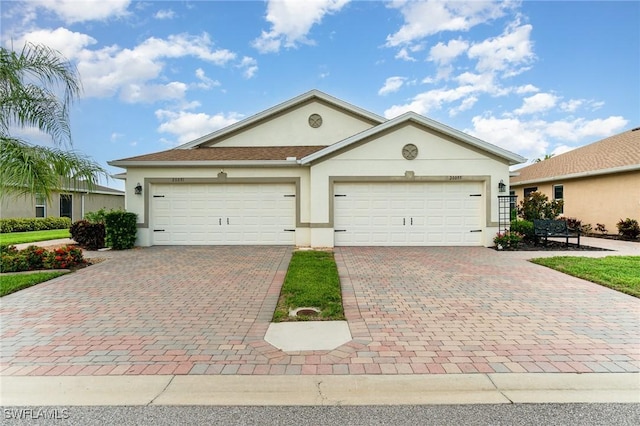 20095 Fiddlewood Ave, North Fort Myers, FL 33917 - ranch-style house with stucco siding, decorative driveway, and a garage