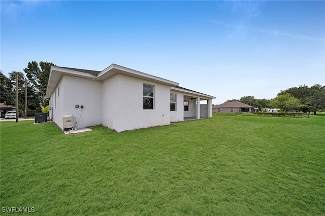3706 16th St W, Lehigh Acres, FL 33971 - rear view of house with stucco siding and a yard