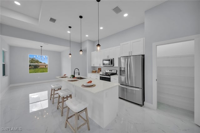 3706 16th St W, Lehigh Acres, FL 33971 - kitchen with stainless steel appliances, light marble finish floors, white cabinetry, a breakfast bar area, and recessed lighting