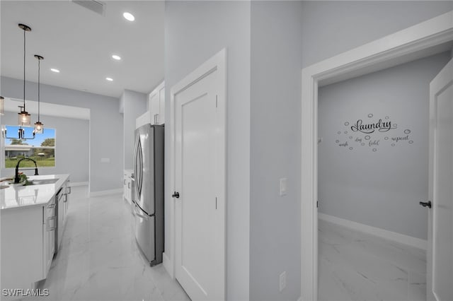 3706 16th St W, Lehigh Acres, FL 33971 - kitchen with freestanding refrigerator, light marble finish floors, recessed lighting, white cabinets, and light countertops