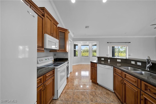 902 E 10th St, Lehigh Acres, FL 33972 - kitchen featuring white appliances, crown molding, brown cabinets, glass insert cabinets, and dark stone countertops