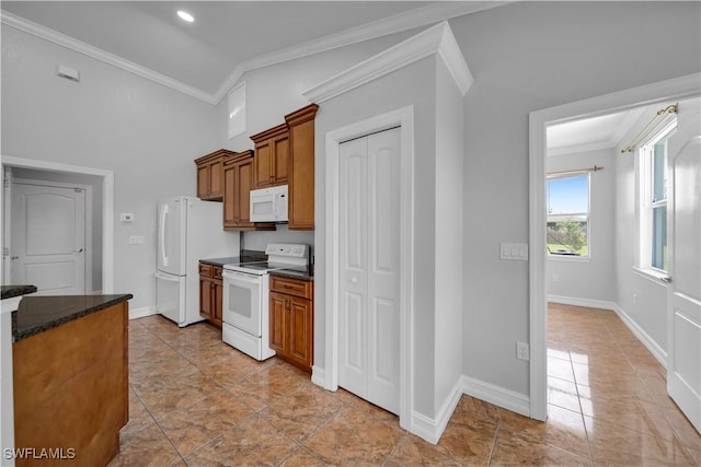 902 E 10th St, Lehigh Acres, FL 33972 - kitchen featuring white appliances, ornamental molding, brown cabinetry, light tile patterned flooring, and dark stone countertops
