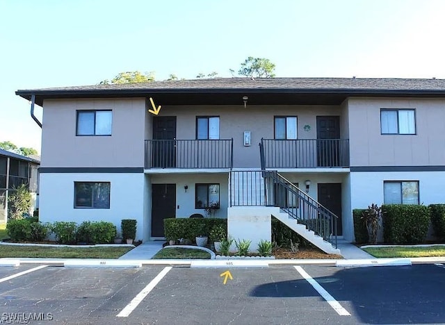 1221 Barrett Rd Unit 905, North Fort Myers, FL 33903 - view of property featuring uncovered parking and stairs