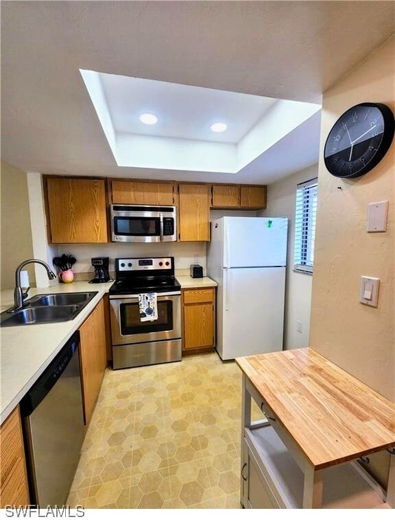 1221 Barrett Rd Unit 905, North Fort Myers, FL 33903 - kitchen featuring appliances with stainless steel finishes, a raised ceiling, brown cabinets, light countertops, and recessed lighting