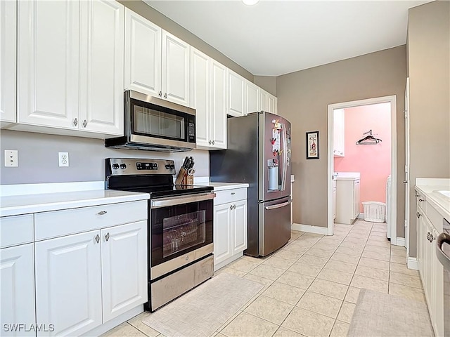 14031 W Hyde Park Dr Unit 201, Fort Myers, FL 33912 - kitchen with stainless steel appliances, light countertops, white cabinetry, and light tile patterned floors