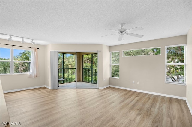 8851 Colonnades Ct W Unit 128, Bonita Springs, FL 34135 - empty room featuring a textured ceiling, light wood-style floors, ceiling fan, and rail lighting