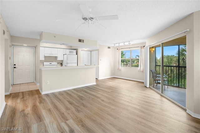 8851 Colonnades Ct W Unit 128, Bonita Springs, FL 34135 - unfurnished living room with ceiling fan, light wood-style floors, and a textured ceiling