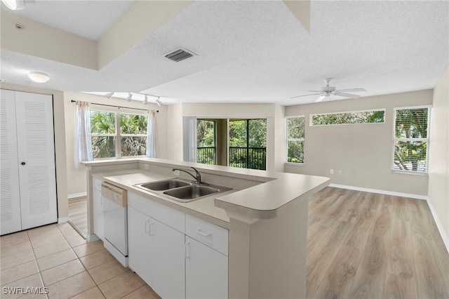 8851 Colonnades Ct W Unit 128, Bonita Springs, FL 34135 - kitchen featuring white dishwasher, plenty of natural light, light countertops, ceiling fan, and a textured ceiling