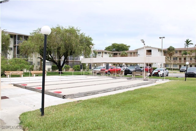 1395 NE 167th St # 107, North Miami Beach, FL 33162 - surrounding community featuring a bocce ball area, uncovered parking, and a yard
