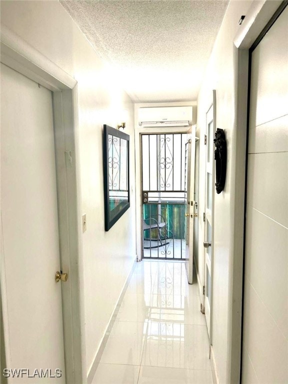 1395 NE 167th St # 107, North Miami Beach, FL 33162 - hall with a wall mounted air conditioner, a textured ceiling, and light tile patterned floors