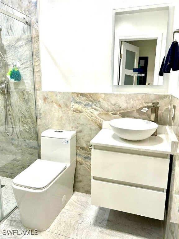 1395 NE 167th St # 107, North Miami Beach, FL 33162 - full bath with tile walls, vanity, a marble finish shower, and marble finish floors