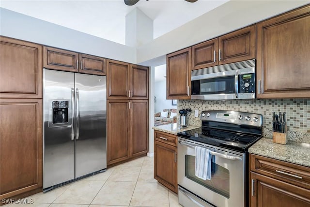 941 Ironwood Ct, Marco Island, FL 34145 - kitchen with stainless steel appliances, tasteful backsplash, light tile patterned flooring, light stone counters, and a ceiling fan