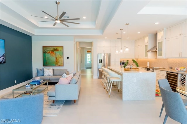 756 108th Ave N, Naples, FL 34108 - living room featuring beverage cooler, a tray ceiling, ceiling fan, recessed lighting, and finished concrete floors