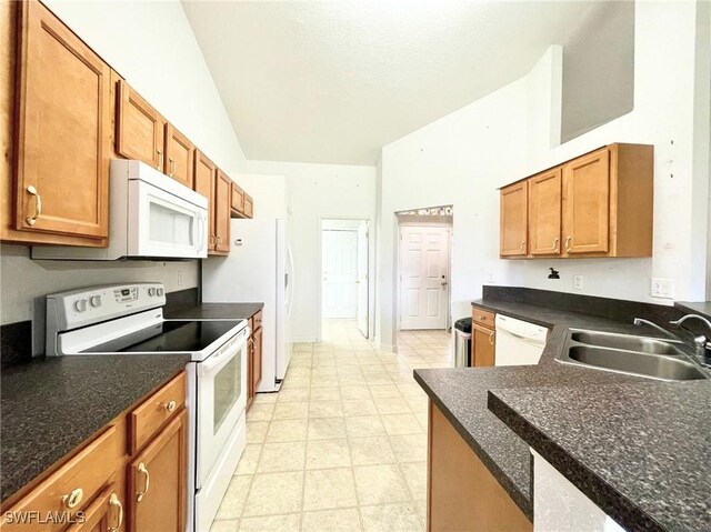 836 Dawhert Ave S, Lehigh Acres, FL 33974 - kitchen featuring white appliances, dark countertops, brown cabinetry, lofted ceiling, and light flooring