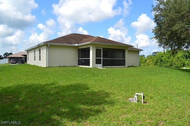 3808 27th St SW, Lehigh Acres, FL 33976 - rear view of house featuring stucco siding, a yard, and a sunroom
