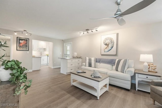 626 12th Ave S Unit 626, Naples, FL 34102 - living room featuring rail lighting, a ceiling fan, and light wood-type flooring