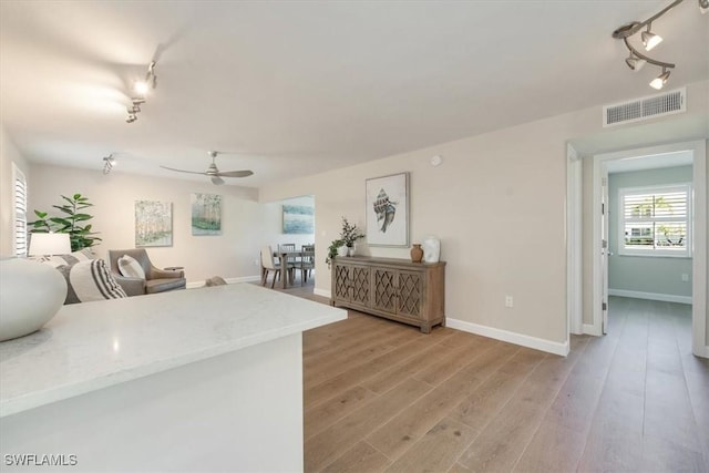 626 12th Ave S Unit 626, Naples, FL 34102 - kitchen featuring rail lighting, a ceiling fan, light wood-type flooring, open floor plan, and light stone counters