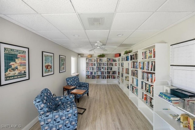 626 12th Ave S Unit 626, Naples, FL 34102 - sitting room featuring wood finished floors, wall of books, a drop ceiling, a ceiling fan, and recessed lighting