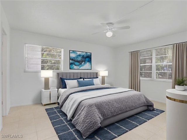 499 Forest Lakes Blvd Unit 207, Naples, FL 34105 - bedroom with tile patterned floors, multiple windows, and a ceiling fan