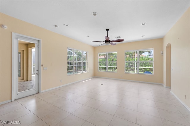 2628 Fairmont Cove Ct, Cape Coral, FL 33991 - empty room featuring healthy amount of natural light, ceiling fan, arched walkways, light tile patterned floors, and recessed lighting