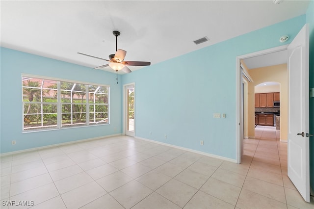 2628 Fairmont Cove Ct, Cape Coral, FL 33991 - spare room with ceiling fan, arched walkways, light tile patterned floors, and a smoke detector