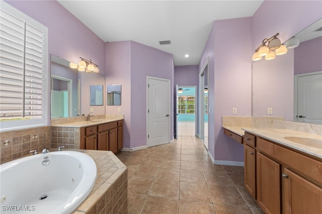 2628 Fairmont Cove Ct, Cape Coral, FL 33991 - full bath with two vanities, a whirlpool tub, and tile patterned floors