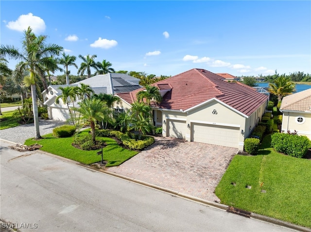 2628 Fairmont Cove Ct, Cape Coral, FL 33991 - mediterranean / spanish house featuring decorative driveway, an attached garage, a front lawn, and stucco siding