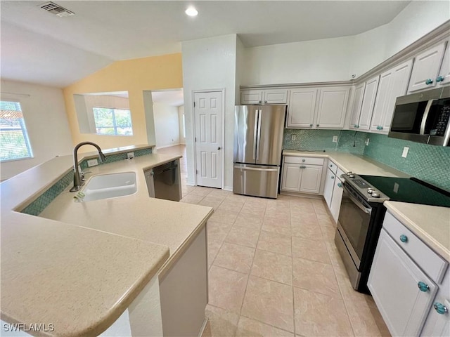 8000 Fountain Mist Blvd, Lehigh Acres, FL 33972 - kitchen featuring stainless steel appliances, vaulted ceiling, backsplash, light countertops, and plenty of natural light