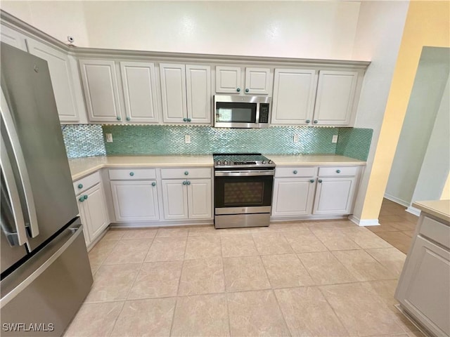 8000 Fountain Mist Blvd, Lehigh Acres, FL 33972 - kitchen with stainless steel appliances, light countertops, tasteful backsplash, and light tile patterned floors