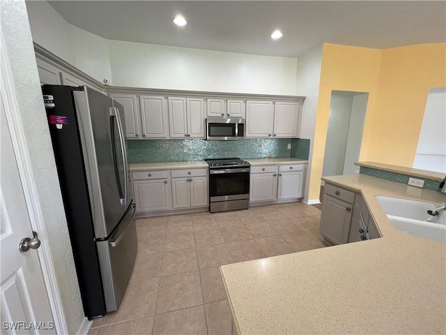 8000 Fountain Mist Blvd, Lehigh Acres, FL 33972 - kitchen with stainless steel appliances, light tile patterned floors, tasteful backsplash, light countertops, and gray cabinets