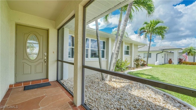 301 SE 26th Ter, Cape Coral, FL 33904 - view of exterior entry with stucco siding and a yard