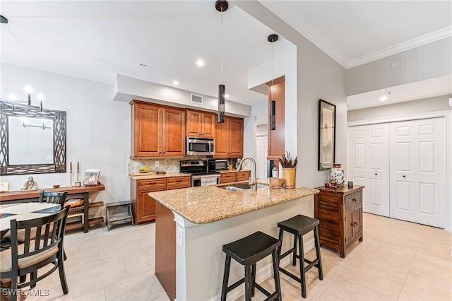 28082 Sosta Ln Unit 2, Bonita Springs, FL 34135 - kitchen with stainless steel appliances, brown cabinets, light tile patterned flooring, light stone counters, and backsplash