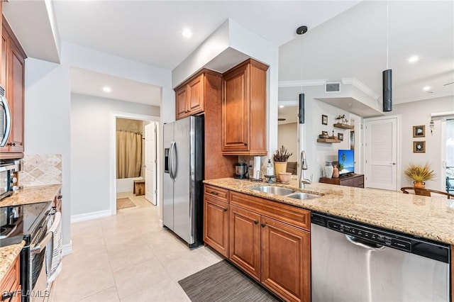 28082 Sosta Ln Unit 2, Bonita Springs, FL 34135 - kitchen with stainless steel appliances, decorative backsplash, light stone counters, brown cabinets, and recessed lighting