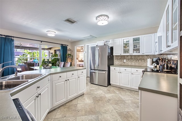 4512 SW 20th Ave, Cape Coral, FL 33914 - kitchen with freestanding refrigerator, tasteful backsplash, white cabinetry, and glass insert cabinets