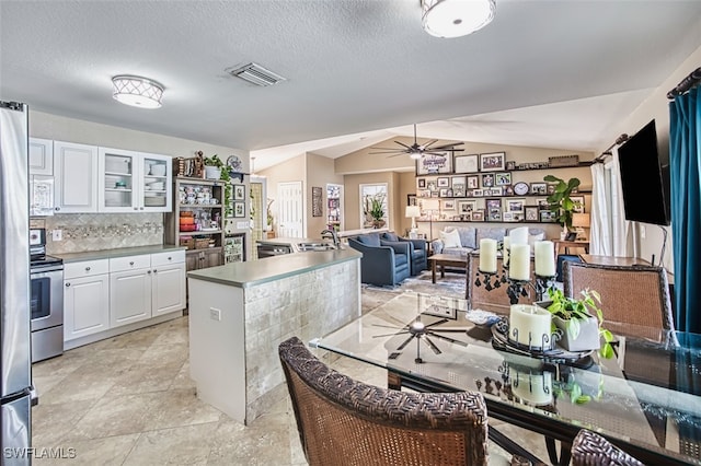 4512 SW 20th Ave, Cape Coral, FL 33914 - kitchen featuring white microwave, electric range, vaulted ceiling, white cabinets, and a ceiling fan