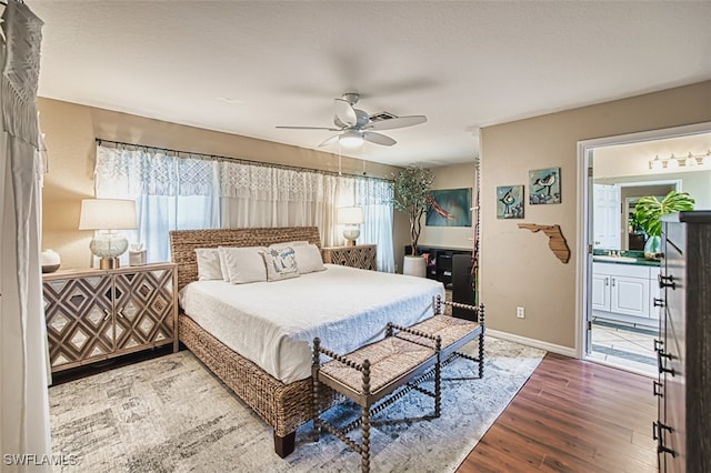 4512 SW 20th Ave, Cape Coral, FL 33914 - bedroom with wood finished floors, multiple windows, ensuite bath, and a ceiling fan
