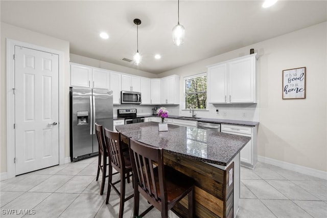 3336 Hampton Blvd, Alva, FL 33920 - kitchen featuring stainless steel appliances, light tile patterned floors, white cabinetry, a breakfast bar, and recessed lighting