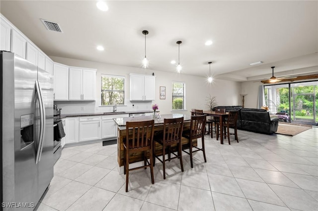 3336 Hampton Blvd, Alva, FL 33920 - kitchen featuring stainless steel fridge with ice dispenser, light tile patterned floors, plenty of natural light, white cabinetry, and recessed lighting