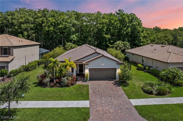 3336 Hampton Blvd, Alva, FL 33920 - single story home with decorative driveway, an attached garage, a lawn, stucco siding, and a tile roof