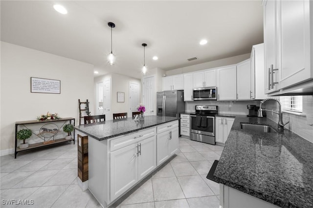 3336 Hampton Blvd, Alva, FL 33920 - kitchen with stainless steel appliances, decorative backsplash, light tile patterned floors, a center island, and recessed lighting