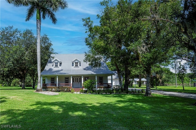 202 N Cypress St, Labelle, FL 33935 - cape cod house with covered porch, a front lawn, and a metal roof