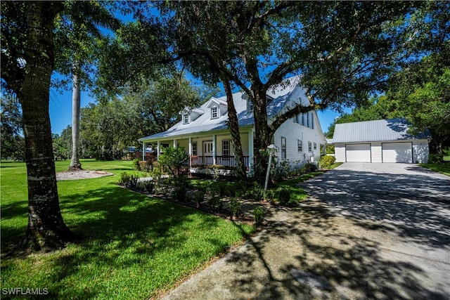 202 N Cypress St, Labelle, FL 33935 - cape cod-style house with an outdoor structure, covered porch, a front yard, and a detached garage