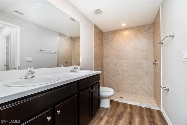 849 Haleybury St, Port Charlotte, FL 33948 - full bathroom featuring double vanity, a tile shower, and wood finished floors