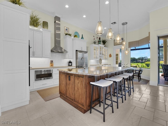 23220 Whispering Ridge Dr, Estero, FL 34135 - kitchen with wall chimney exhaust hood, recessed lighting, high end refrigerator, backsplash, and a large island