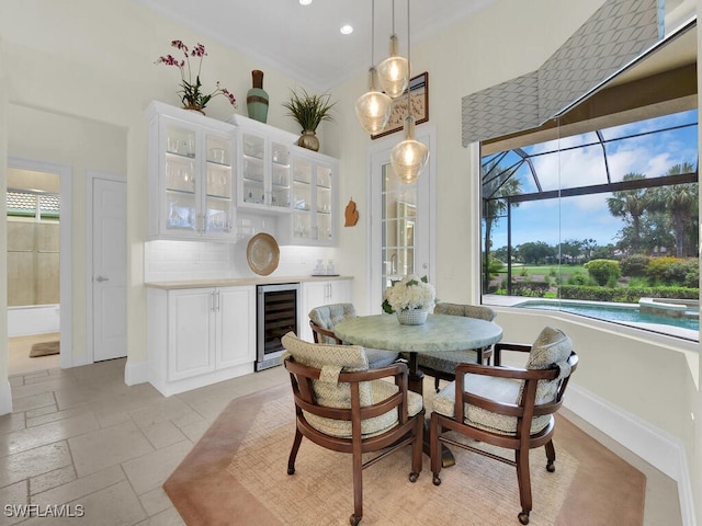 23220 Whispering Ridge Dr, Estero, FL 34135 - dining room with wine cooler, a dry bar, recessed lighting, and stone tile flooring