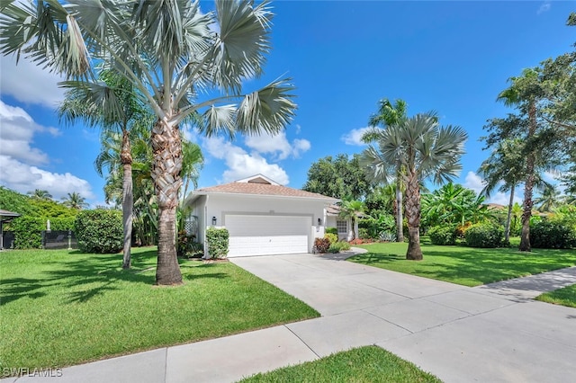 973 Summerfield Dr, Naples, FL 34120 - view of front facade featuring stucco siding, a front lawn, an attached garage, and concrete driveway