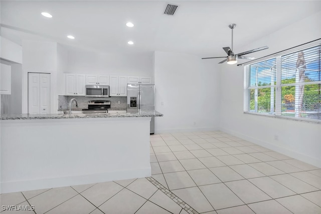 973 Summerfield Dr, Naples, FL 34120 - kitchen featuring appliances with stainless steel finishes, ceiling fan, decorative backsplash, white cabinets, and light stone counters