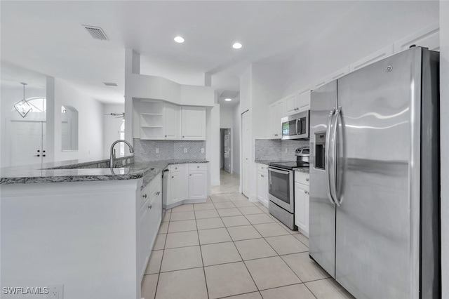973 Summerfield Dr, Naples, FL 34120 - kitchen featuring appliances with stainless steel finishes, open shelves, white cabinetry, backsplash, and light stone countertops