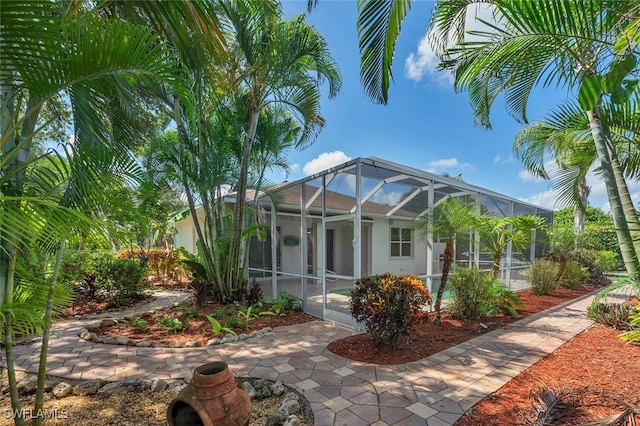 973 Summerfield Dr, Naples, FL 34120 - rear view of house featuring glass enclosure, stucco siding, and an outdoor pool